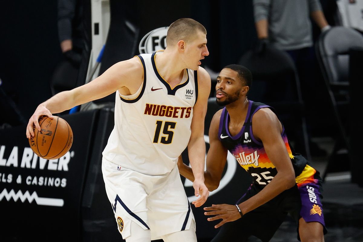 Nikola Jokic of the Denver Nuggets handles the ball against Mikal Bridges of the Phoenix Suns during the NBA game at Phoenix Suns Arena on January 23, 2021 in Phoenix, Arizona.&nbsp;