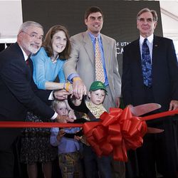 Dr. Lorris Betz, left, senior vice president for health sciences at the University of Utah; heart transplant recipient Emily Roosevelt, her husband, Peter Foehl, and sons Liam and Mason Foehl; and U. President Michael K. Young help cut the ribbon at the open house for the new $200 million Patient Care Pavilion at University Hospital in Salt Lake City on Thursday.