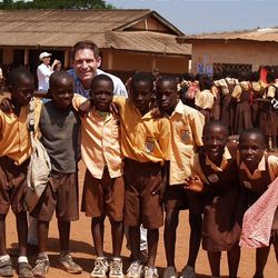 Steve Young stands with kids in Ghana.