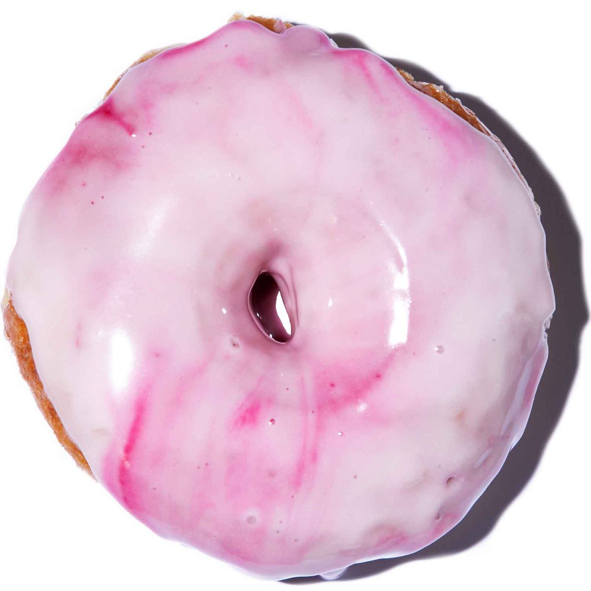 A vegan doughnut glazed with pink frosting