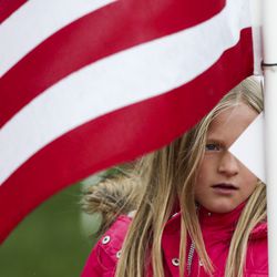 Savanna Skousen, 9, reads a biography of a victim of the 9/11 attacks attached to a flag at the 18th annual Healing Field in Sandy on Wednesday, Sept. 11, 2019. Skousen’s parents brought her and her four siblings to experience the field because they believe it is important to remember the event, even though the children weren’t alive when the attacks took place.