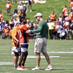Broncos WR Emmanuel Sanders shakes hands and talks with former Broncos QB Peyton Manning after practice.