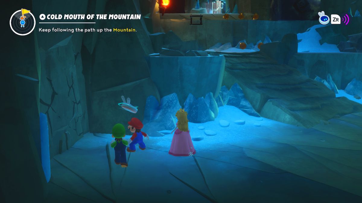 Mario, Luigi, and Peach stand in front of a cracked wall in an ice cave in Mario + Rabbids Sparks of Hope