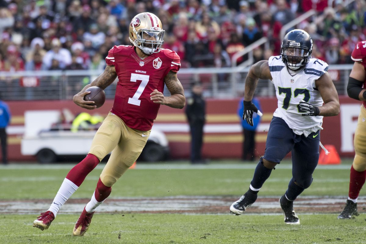 San Francisco 49ers quarterback Colin Kaepernick runs the football against Seattle Seahawks defensive end Michael Bennett during the first quarter at Levi’s Stadium.
