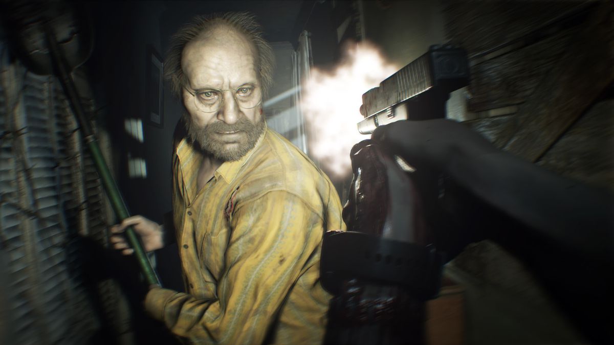 In this Resident Evil 7 screenshot, the antagonist Jack is seen approaching the main character with a shovel raised, ready to attack. The main characters bloodied hands can be seen, aiming a pistol and shooting it at the crazed attacker.