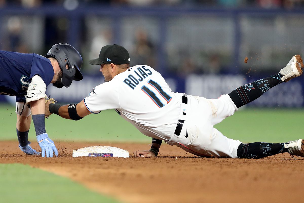 Miguel Rojas #11 of the Miami Marlins tags out Jesse Winker #27 of the Seattle Mariners during the ninth inning at loanDepot park