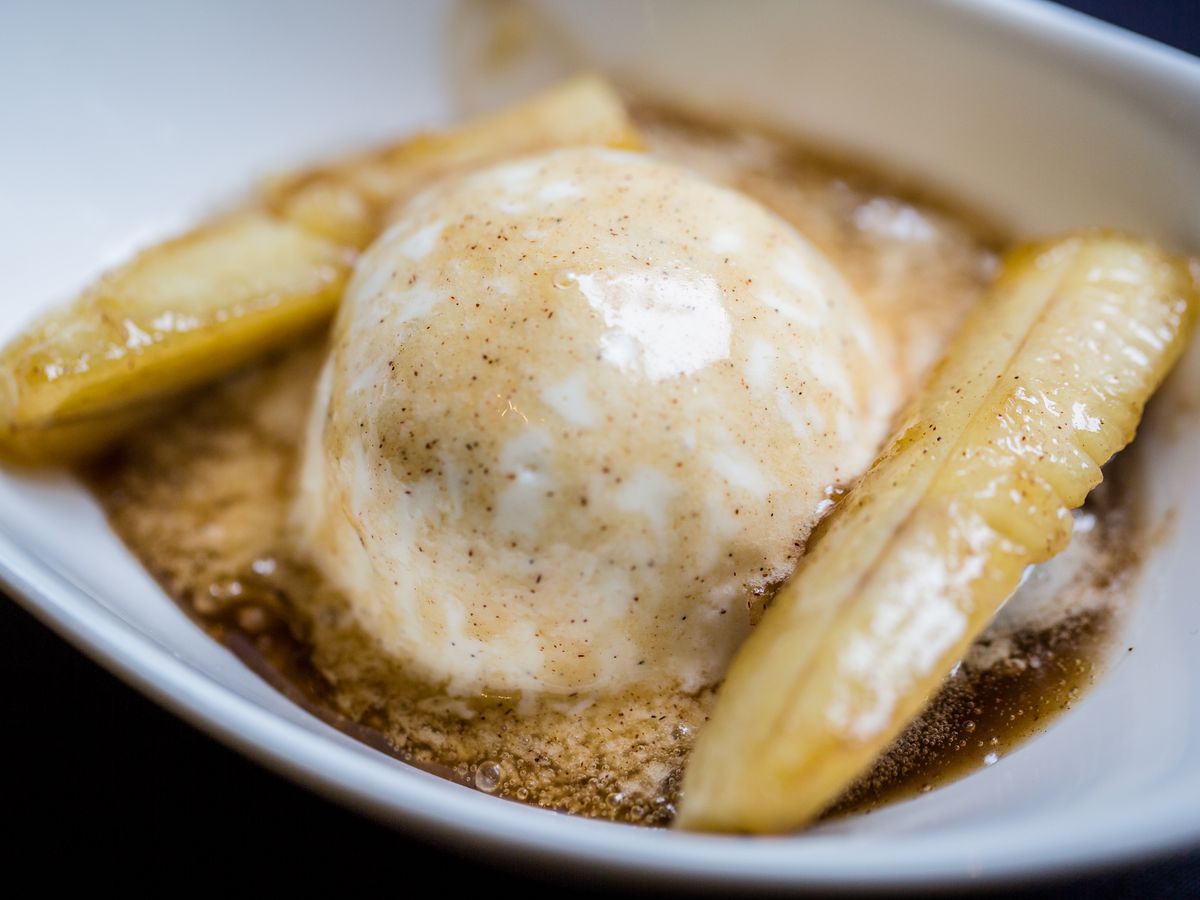 A bowl of bananas sliced lengthwise and flambéed in dark rum, banana liqueur, sugar, and cinnamon, served hot over vanilla ice cream