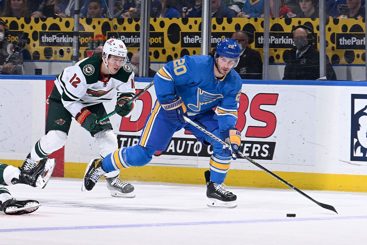 Brandon Saad #20 of the St. Louis Blues controls the puck as Matt Boldy #12 of the Minnesota Wild pressures at the Enterprise Center on April 16, 2022 in St. Louis, Missouri.