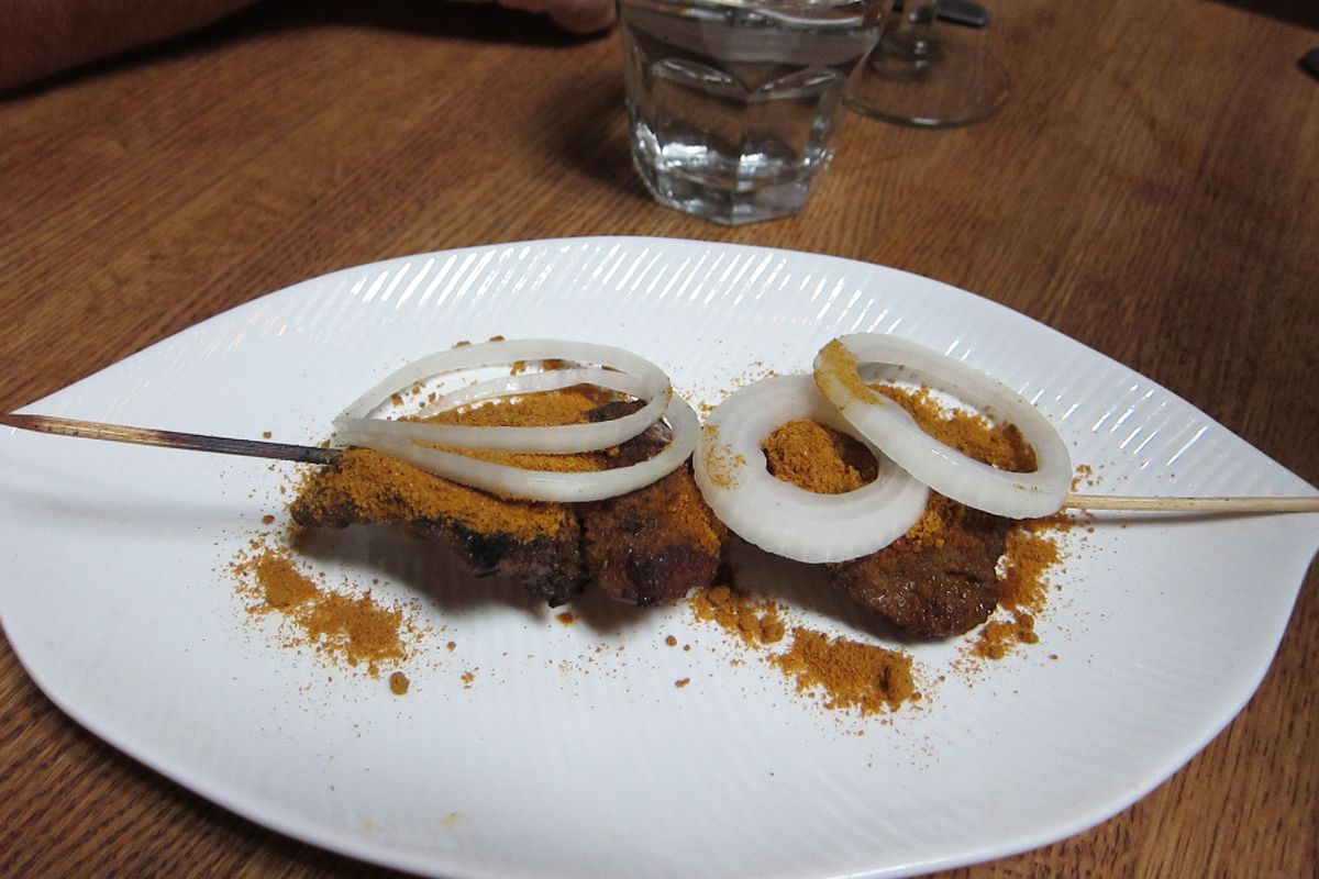 Lamb suya dusted with peanut served on a white plate.