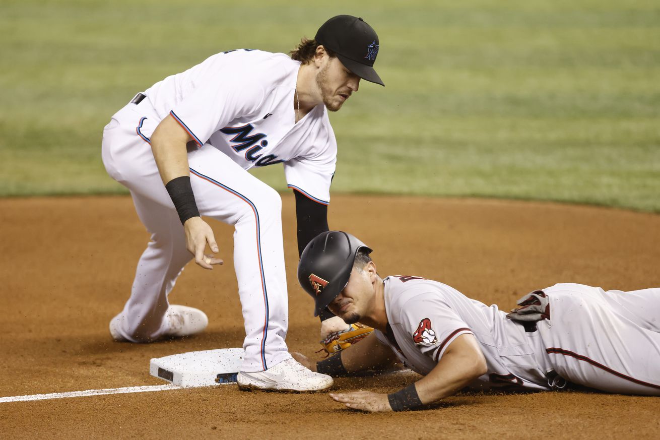Josh Rojas #10 of the Arizona Diamondbacks safely slides into the third base past the tag of Brian Anderson #15 of the Miami Marlins during the fifth inning at loanDepot park on May 06, 2021 in Miami,