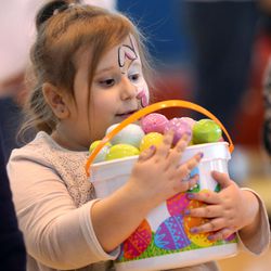 Gracie Davis holds a bucket of eggs she collected in the annual Easter egg hunt at Shriners Hospital for Children in Salt Lake City Wednesday, March 23, 2016.