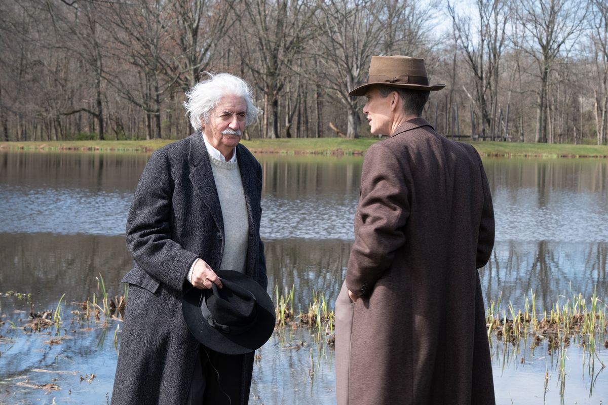 Tom Conti as Albert Einstein and Cillian Murphy as J. Robert Oppenheimer have a chat by a lake in the film Oppenheimer