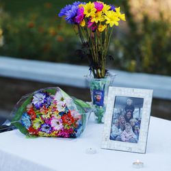 Flowers and photos on display during a vigil for the Strack family at Pioneer Park in Provo Thursday, Oct. 2, 2014. 