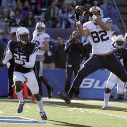 BYU's Kaneakua Friel (82) catches a touchdown pass against Nevada's Bryan Lane Jr. during the second half of an NCAA college football game in Reno, Nev., on Saturday, Nov. 30, 2013. BYU won 28-23.