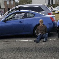 In this image taken Thursday, Dec. 1, 2016, and provided by Marie Turner, Ronald Gasser sits next to his car shortly after he shot ex-NFL football player Joe McKnight at Behrman Highway and Holmes Blvd., in the New Orleans suburb of Terrytown, La. People at right are administering aid to McKnight. Gasser was arrested late Monday, Dec. 5, 2016, jailed on a charge of manslaughter. Gasser was initially taken into custody after the shooting last Thursday, but he was released without being charged pending further investigation into the road rage shooting. (Marie Turner via AP)