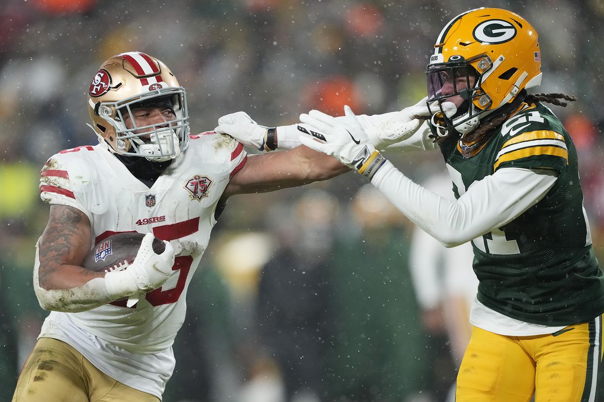 Running back Elijah Mitchell #25 of the San Francisco 49ers carries the ball as cornerback Eric Stokes #21 of the Green Bay Packers defends during the second half of the NFC Divisional Playoff game at Lambeau Field on January 22, 2022 in Green Bay, Wisconsin.