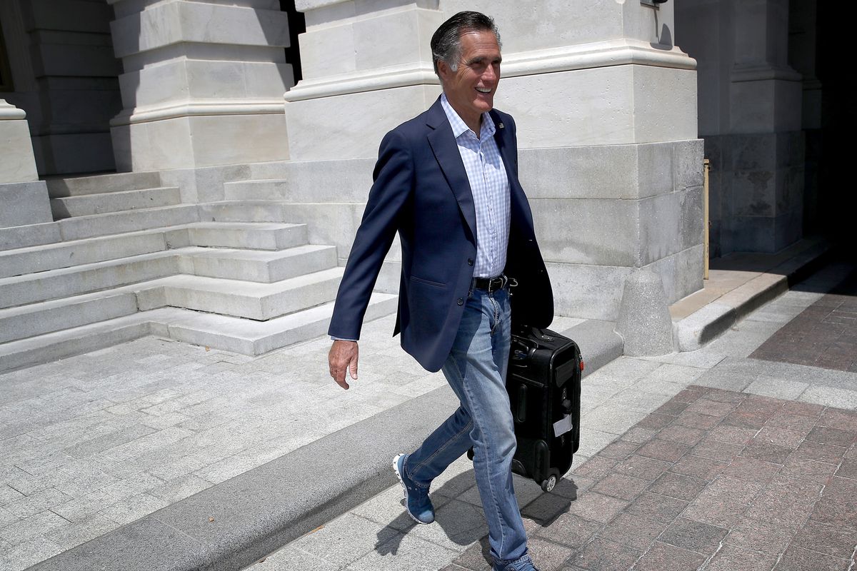 Carrying his suitcase, Senator Mitt Romney departs down the US Capitol steps.