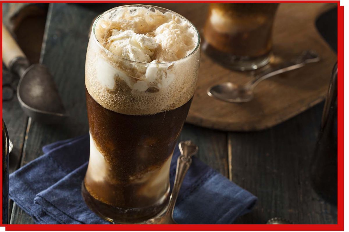 A glass holds a stout float, a scoop of vanilla ice cream floating in dark beer.