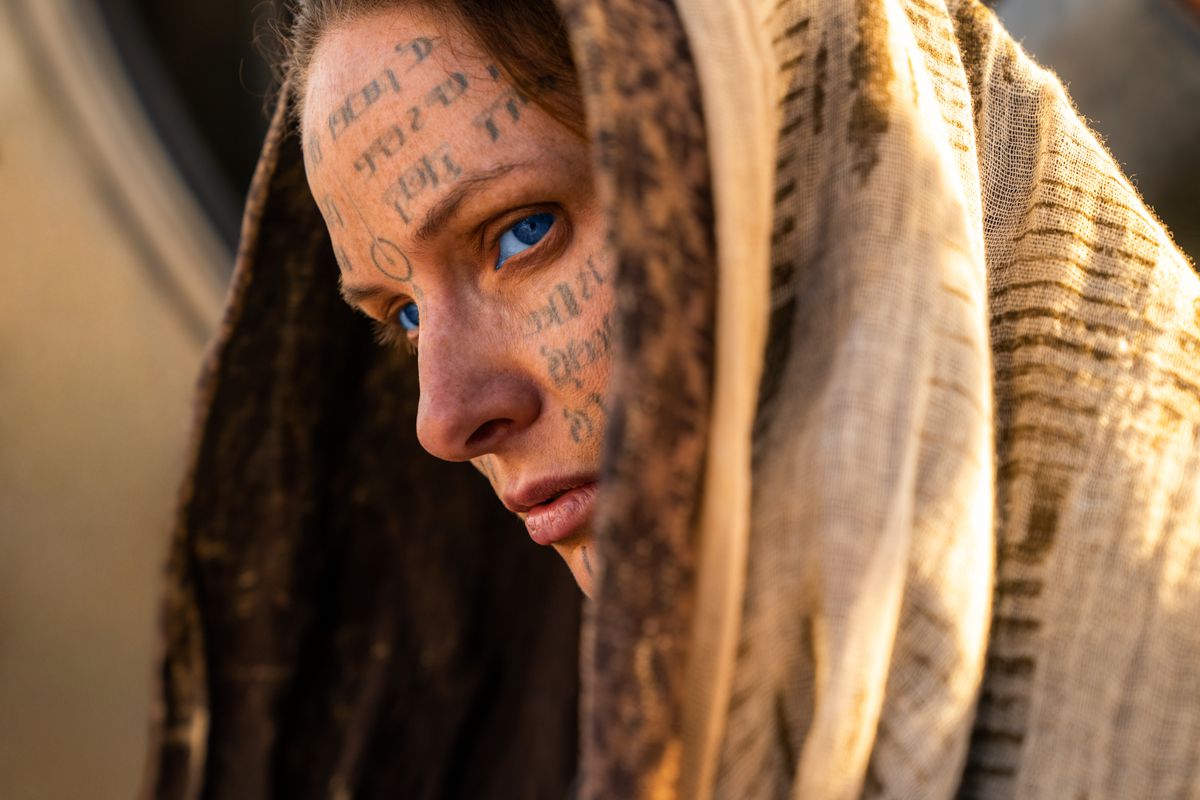 Lady Jessica’s (Rebecca Ferguson) tattooed face peeking out from under a shawl in Dune: Part Two
