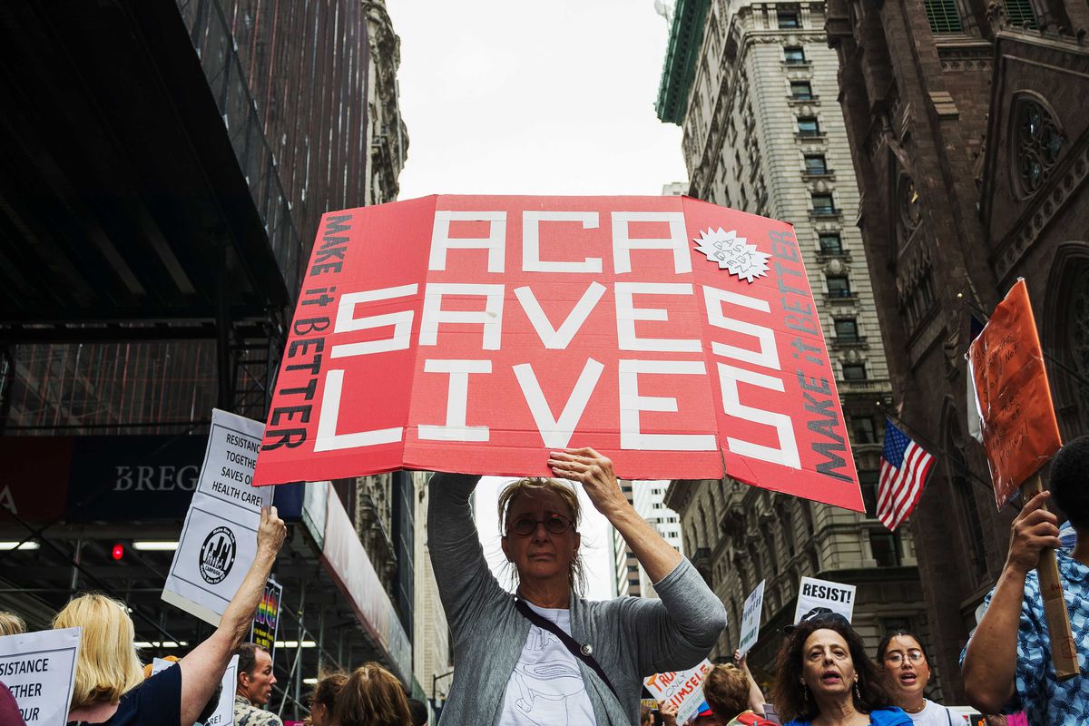 A woman holds a sign that reads “ACA Saves Lives” during a protest in midtown Manhattan.