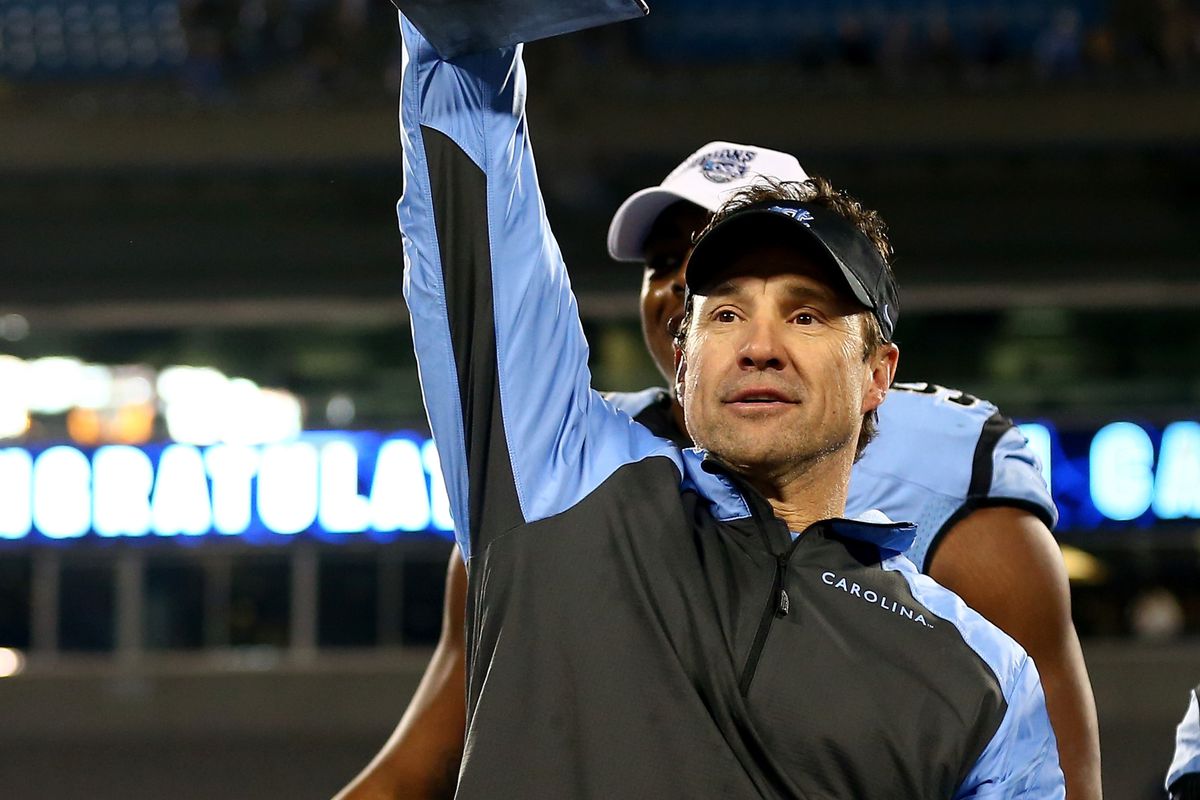CHARLOTTE, NC - DECEMBER 28: Head coach Larry Fedora of the North Carolina Tar Heels celebrates with the trophy after defeating the Cincinnati Bearcats 39-17 at Bank of America Stadium on December 28, 2013 in Charlotte, North Carolina.