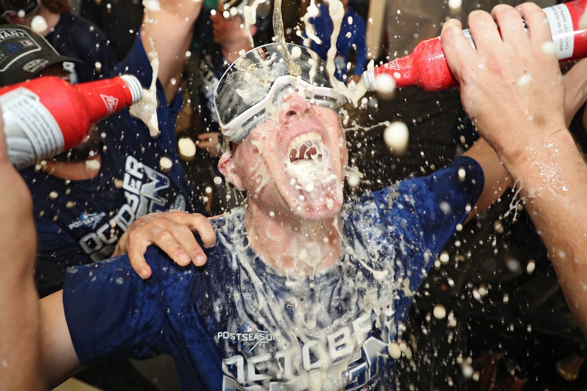Hitting coach and hitting strategist Brant Brown #37 of the Los Angeles Dodgers celebrates with his team in the clubhouse after defeating the Baltimore Orioles and clinching the National League West Division Title at Oriole Park at Camden Yards on September 10, 2019 in Baltimore, Maryland.