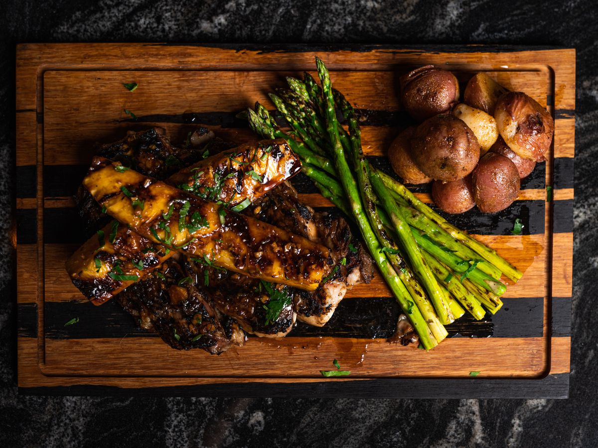 The Warwick’s Hawaiian rib-eye topped with pineapple, and served with asparagus and baby potatoes.
