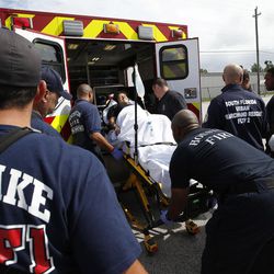 Utah Task Force 1 members and Houston fire load a woman in labor into an emergency vehicle in a parking lot during Tropical Storm Harvey in Houston on Wednesday, Aug. 30, 2017. The woman and her husband were driving around looking for a hospital and came across the responders.