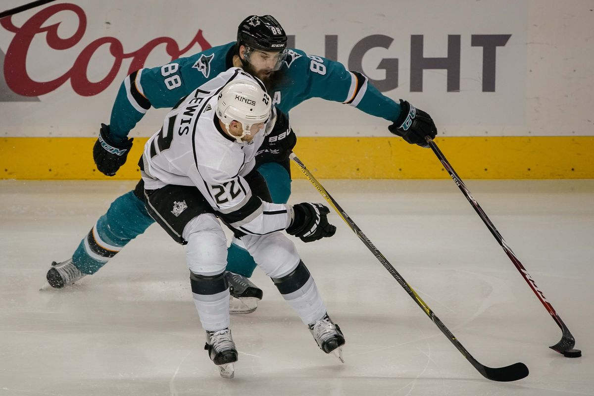Dec 23, 2017; San Jose, CA, USA; San Jose Sharks defenseman Brent Burns (88) and Los Angeles Kings center Trevor Lewis (22) fight for control of the puck during the third period at SAP Center at San Jose.