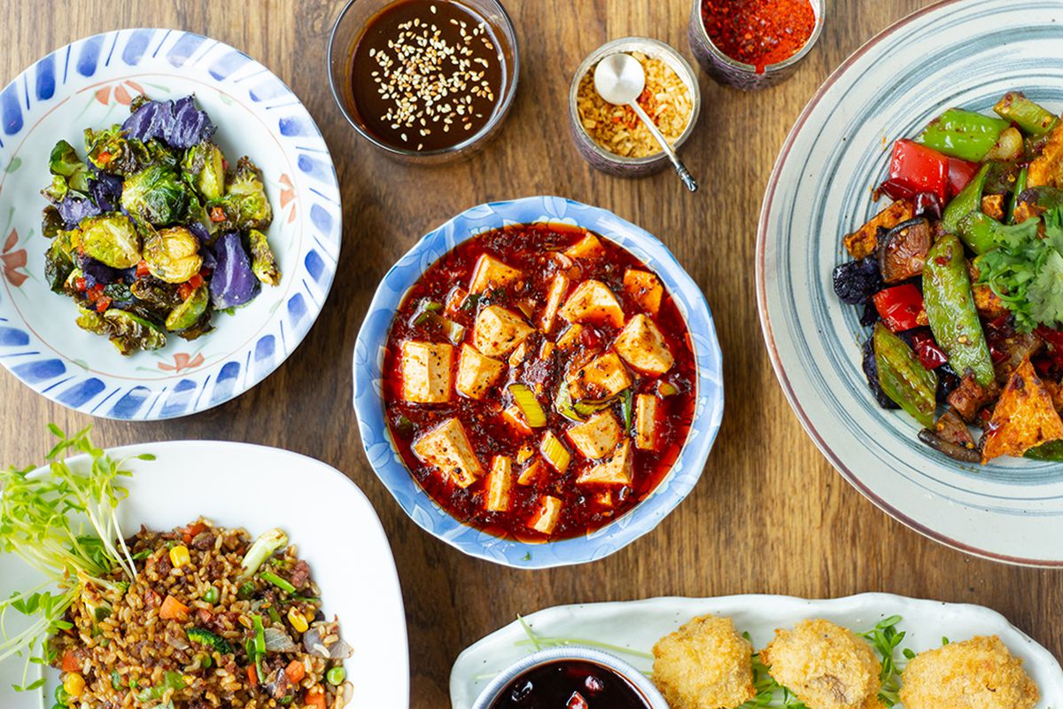 A variety of vegan dishes, including mapo tofu, sauteed brussels sprouts, and fried rice.