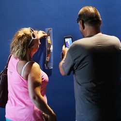 A couple takes a photo of their new glasses as shoppers line up to buy eclipse glasses at Clark Planetarium in Salt Lake City on Wednesday, Aug. 16, 2017, in preparation for Monday's eclipse.