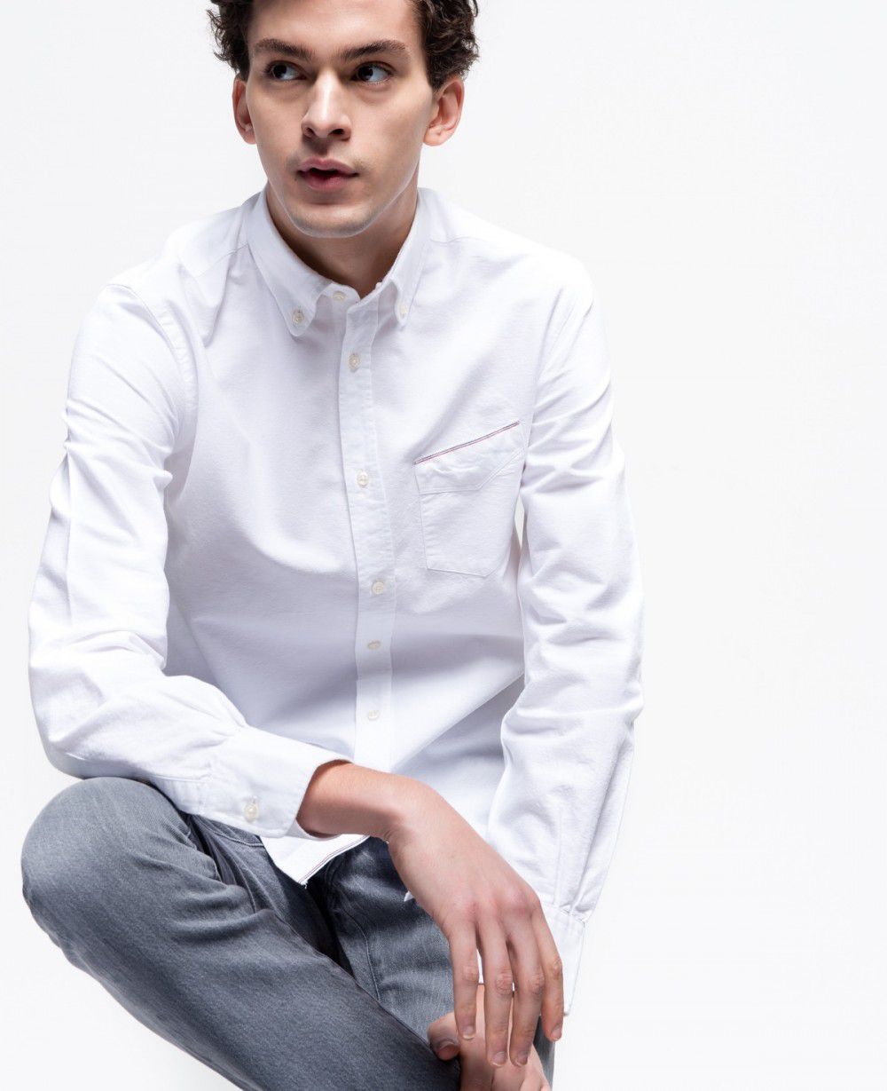 A male model wearing a white button down shirt