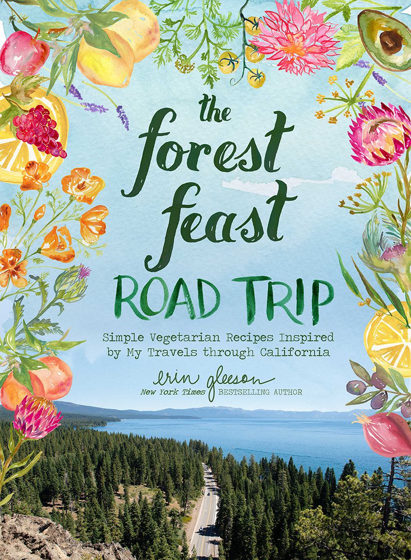 The cover image of The Forest Feast Road Trip: a panoramic view of a coastal highway, surrounded by a border of watercolored flowers.