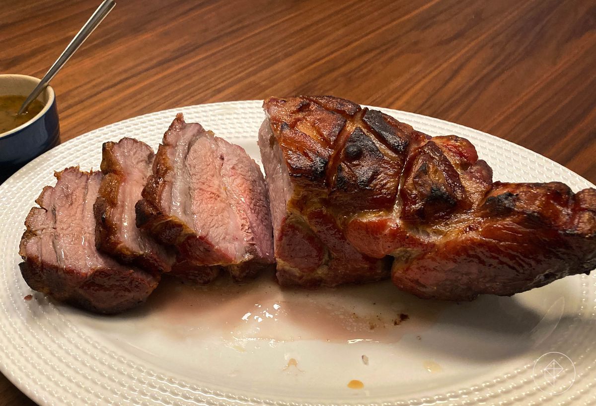 A roast pork butt sitting on a white platter.