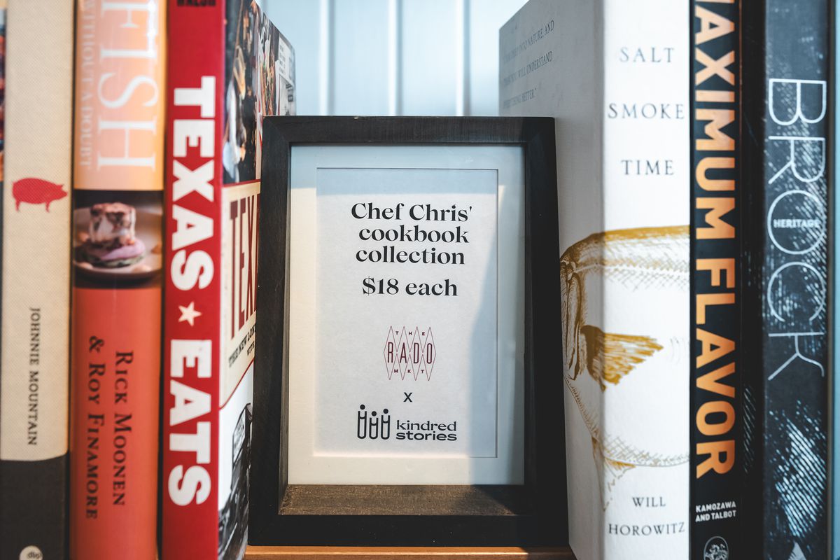 A close up of a sign in the Rado Market’s book nook that reads “Chef Chris’ cookbook collection - $18 each.”