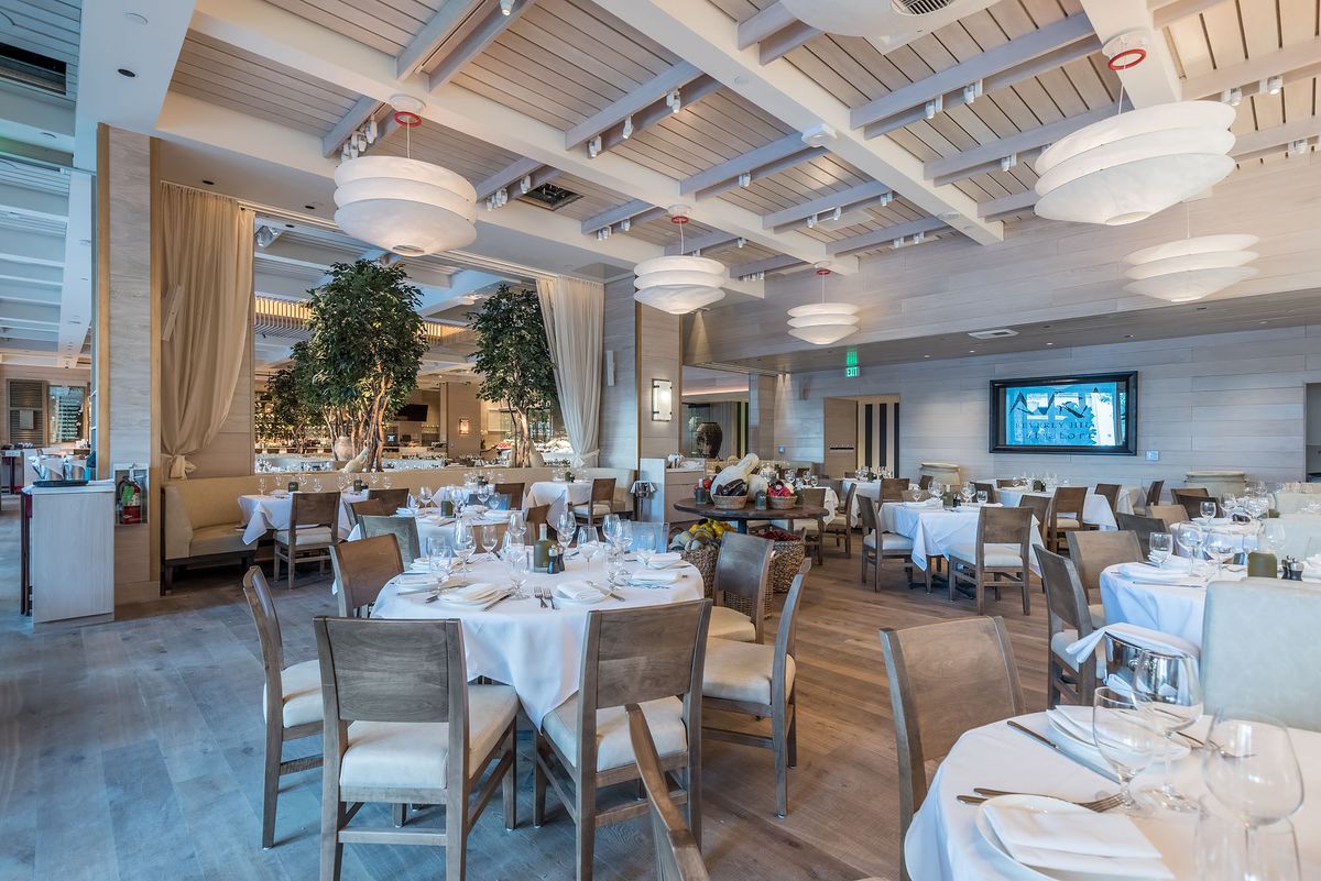 A classy interior of a Greek restaurant in Beverly Hills with high ceilings and modern furniture.