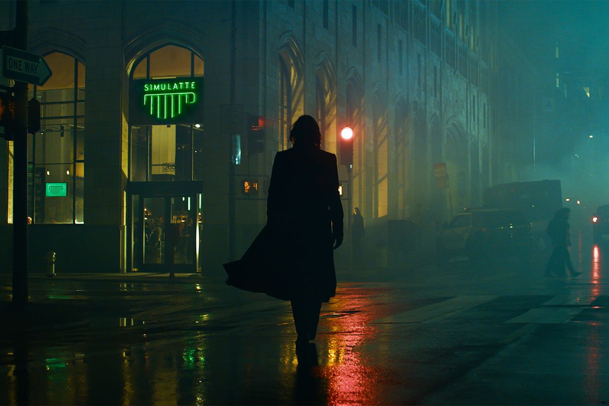 a silhouetted Neo walks toward a coffee shop called Simulatte in The Matrix Resurrections