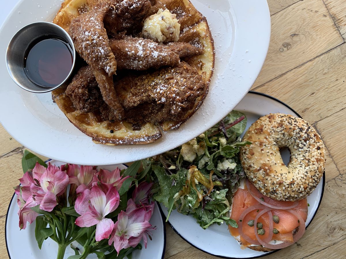 A bagel, a dish of chicken and waffles, and some flowers at Pioneer Square D&amp;E