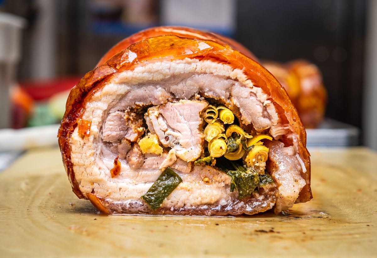 A cross section of rolled pork belly lechon complete with bronze, crispy skin, juicy pale meat, and a lemongrass and garlic stuffing at Kuya Ja’s Lechon Belly.