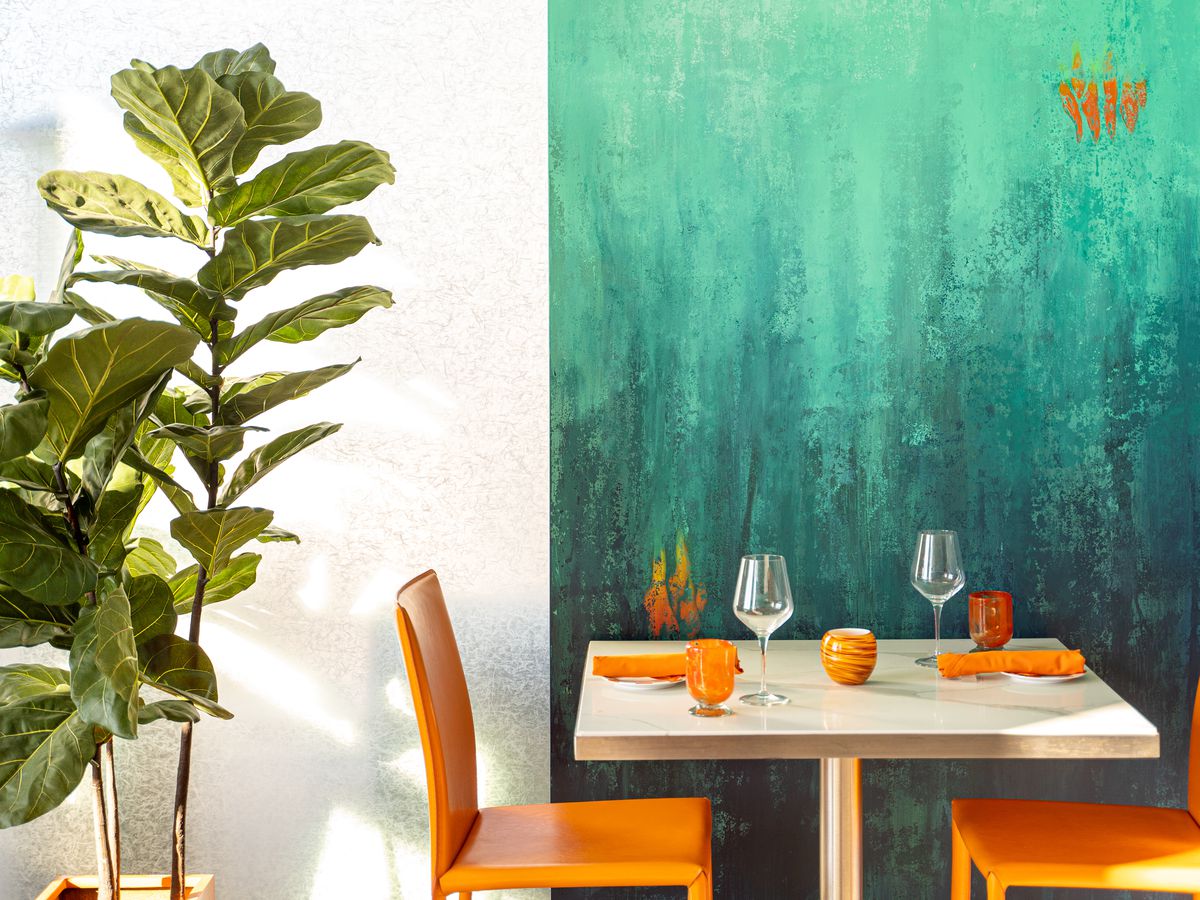 A table to two in front of an undersea mural.