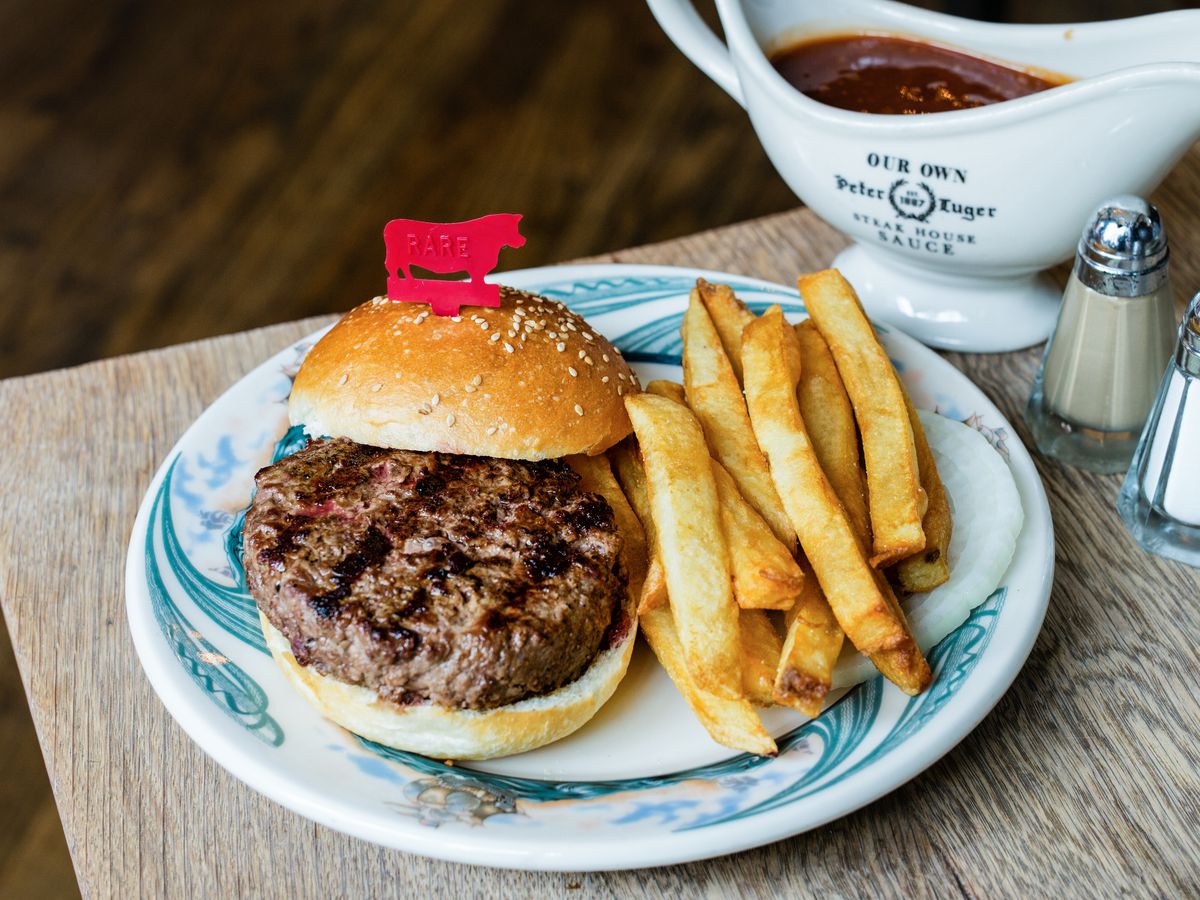 Peter Luger’s hamburger with fries, on a white plate with blue markings.
