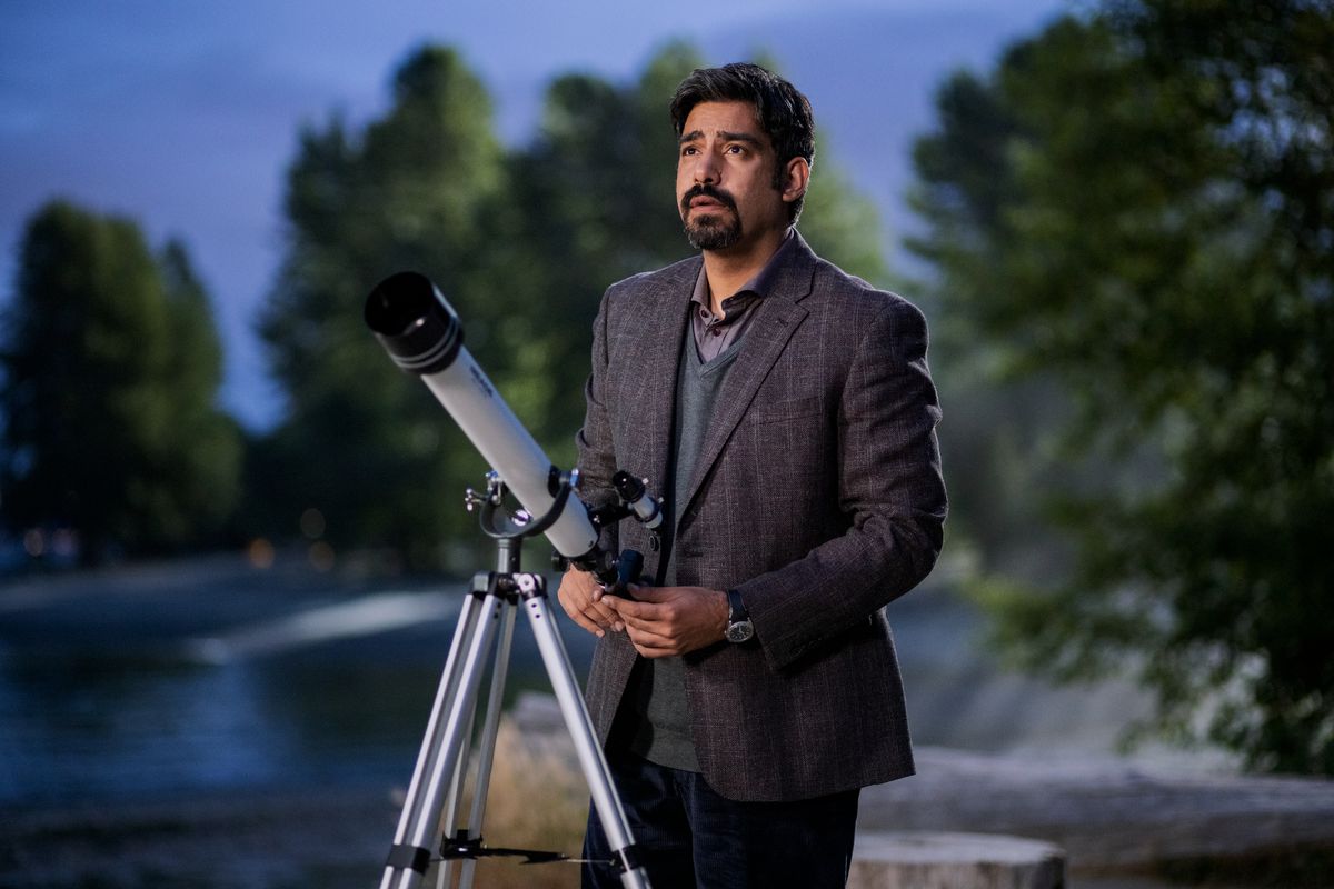 Vincent, played by Rahul Kohli, standing behind a telescope looking up at the sky in Netflix’s The Midnight Club
