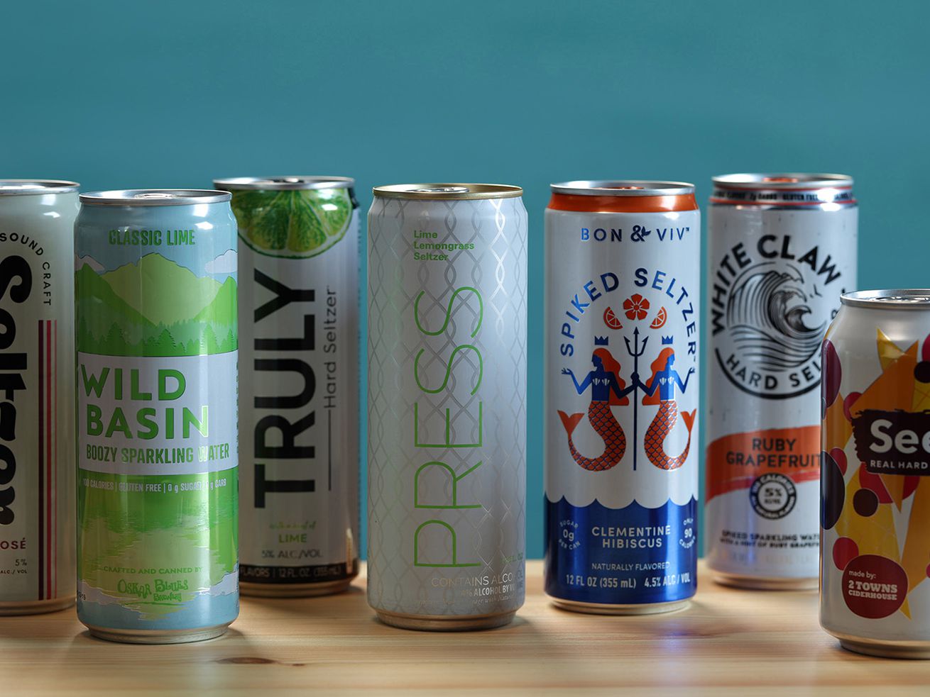 A row of cans of hard seltzer placed on a wooden countertop