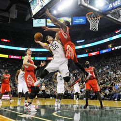 Utah Jazz shooting guard Gordon Hayward (20) is fouled by Houston Rockets point guard Aaron Brooks (0) while shooting during a game at EnergySolutions Arena on Monday, Dec. 2, 2013.