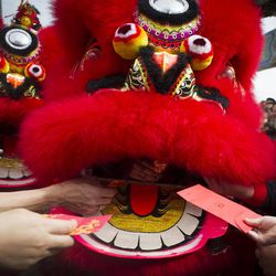 Temple visitors give red packets to the lion dance troupe during the lion dance performance on the first day of Chinese Lunar New Year at a temple in Kuala Lumpur, Malaysia on Thursday, Feb. 19, 2015. Chinese people are celebrating the arrival of the Lunar New Year, the Year of the Sheep. 
