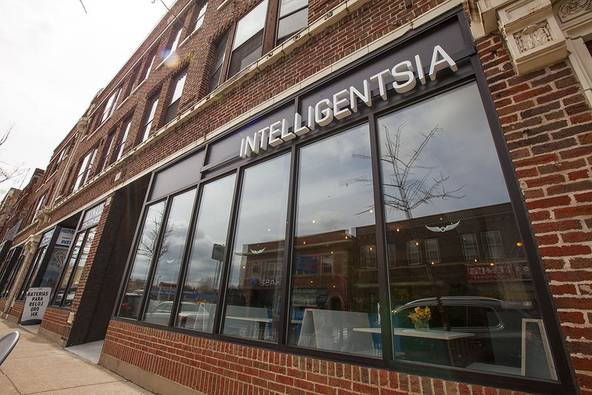 A storefront cafe in a brick building with a large sign that reads “Intelligentsia.”