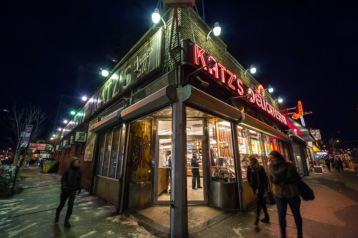 The exterior of a lit-up Katz’s Delicatessen at night.