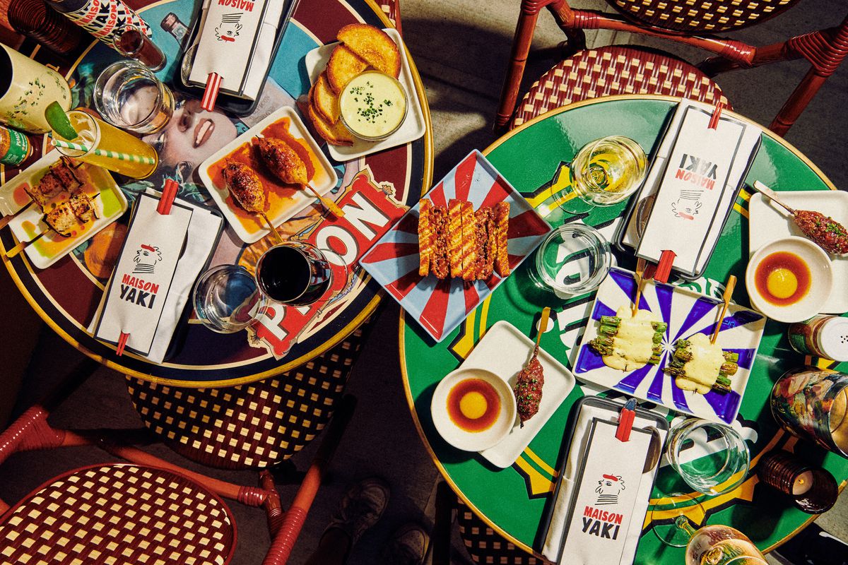 An overhead photograph of a spread of skewers on two colorful tables at Maison Yaki in Prospect Heights.