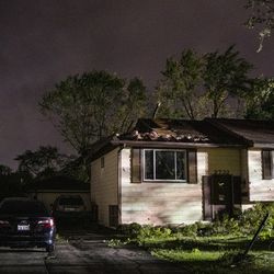 A home with a damaged roof sits on Everglade Ave, after a tornado touched down near suburban Woodridge, Monday, June 21, 2021.