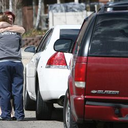 Two women hug after talking to police during an investigation of a shooting in American Fork on Friday, April 5, 2013.
